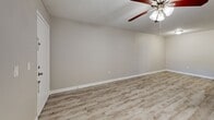 Located at 3706 W Idlewild Ave in Leto, FL, this one-bedroom, one-bathroom unit offers a practical and well-appointed layout across a single floor. The open-concept living, dining, and kitchen area forms the heart of the unit, finished with light wood-look luxury vinyl plank flooring and neutral-toned walls throughout. A ceiling fan with light fixture overhead serves both the living and dining areas, while a window allows natural light to fill the space. The kitchen features warm wood cabinetry, granite-style countertops, a peninsula with breakfast bar, and black appliances including a range, microwave, refrigerator, and dishwasher. A louvered closet door in the kitchen provides additional storage. The bedroom is carpeted for comfort, features a window with outdoor views, and is connected to a closet area. A second closet adds further storage convenience. In-unit laundry is also included. The bathroom is finished with tile-surround tub and shower combination, granite-top vanity with undermount sink, and matching wood-look flooring. A textured ceiling is consistent throughout the unit, adding a classic residential character to the overall design.