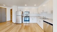 Located at 2955 NE 11th St in Renton, WA, this 2-bedroom, 3-bathroom residence offers a clean, modern design across a single thoughtfully arranged floor. The open-concept living and kitchen area is anchored by light hardwood flooring and bright white walls, creating an airy, welcoming atmosphere. Large windows and a private balcony access from the living area allow natural light to fill the space and provide outdoor views. The kitchen features white cabinetry with brushed nickel hardware, stainless steel appliances including a refrigerator, range, microwave, and dishwasher, along with ample counter and storage space. A dedicated laundry area adds everyday convenience. The two bedrooms offer comfortable, well-proportioned spaces — the primary bedroom features hardwood flooring, while the secondary bedroom is finished with plush carpet. Three closets throughout the home provide generous storage. The three bathrooms are finished with light wood-toned cabinetry, neutral countertops, and hardwood flooring, with one featuring a bathtub and shower combination. Warm wood-trimmed doorways and recessed lighting add refined touches throughout, contributing to a cohesive, modern aesthetic.