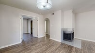 Located in Scottsdale, AZ, this single-floor residence offers a thoughtfully arranged layout with consistent wood-look flooring throughout, creating a cohesive and modern aesthetic. The living area is a welcoming focal point, featuring a tile-surround fireplace, a ceiling fan, and an elegant arched passageway that connects the main living spaces. Natural light filters in through blinds-covered windows, brightening the neutral gray and white tones found across the home.

The kitchen is well-appointed with white cabinetry, light stone-style countertops, and a full suite of stainless steel appliances, including a range, over-the-range microwave, dishwasher, and refrigerator. A corner sink with a window above adds both functionality and natural light to the space.

The bedrooms are generously proportioned, each with ceiling fans and ample closet storage, including a walk-in closet with built-in shelving in one room. The bathroom features a long vanity with dual sinks, stone-style countertops, and a separate tub and toilet area. A dedicated laundry room accommodates a full-size washer and dryer side by side. The clean, neutral palette and modern finishes throughout make this a move-in-ready Scottsdale residence.
