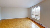 Located at 56 Main St N in Markham, Ontario, this one-bedroom, one-bathroom unit offers a well-organized and functional layout across a single floor. Warm parquet hardwood flooring runs throughout the space, adding a classic and timeless character to every room.

The open-concept living and dining area is generously sized, bathed in natural light through large windows that frame views of the surrounding treetops and neighbourhood. A sliding door provides direct access to a private balcony, extending the living space outdoors. Baseboard heating ensures year-round comfort.

The kitchen is efficiently designed, featuring white cabinetry, stone-look laminate countertops, a double-basin sink, and a white electric range. Ample upper and lower cabinet storage makes the kitchen both practical and organized.

The bedroom offers a comfortable footprint, complete with a built-in double closet for storage and a window that allows natural light to fill the room. Consistent parquet flooring continues throughout.

The bathroom is clean and bright, appointed with a full-sized soaker tub with overhead shower, white vanity cabinetry, and a large mirror. Safety grab bars are thoughtfully included in the tub area. The overall ambiance of the unit is light, neutral, and move-in ready.