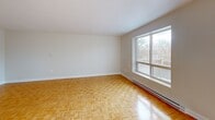Located at 56 Main St N in Markham, Ontario, this one-bedroom, one-bathroom unit offers a well-organized and functional layout across a single floor. Warm parquet hardwood flooring runs throughout the space, adding a classic and timeless character to every room.

The open-concept living and dining area is generously sized, bathed in natural light through large windows that frame views of the surrounding treetops and neighbourhood. A sliding door provides direct access to a private balcony, extending the living space outdoors. Baseboard heating ensures year-round comfort.

The kitchen is efficiently designed, featuring white cabinetry, stone-look laminate countertops, a double-basin sink, and a white electric range. Ample upper and lower cabinet storage makes the kitchen both practical and organized.

The bedroom offers a comfortable footprint, complete with a built-in double closet for storage and a window that allows natural light to fill the room. Consistent parquet flooring continues throughout.

The bathroom is clean and bright, appointed with a full-sized soaker tub with overhead shower, white vanity cabinetry, and a large mirror. Safety grab bars are thoughtfully included in the tub area. The overall ambiance of the unit is light, neutral, and move-in ready.