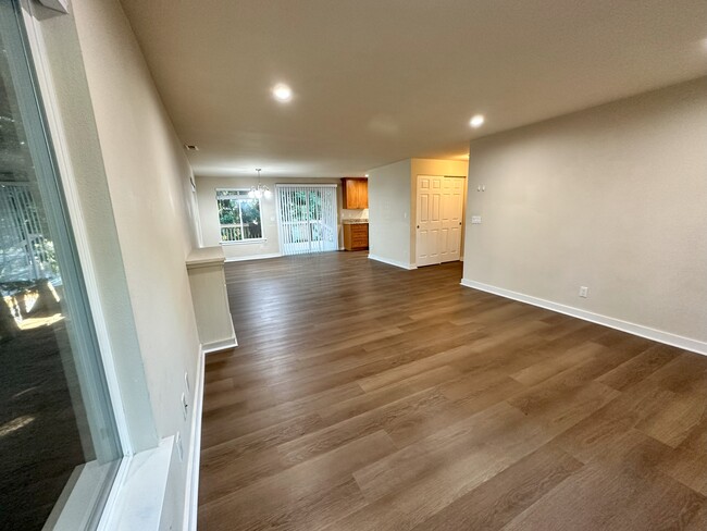 Spacious living room with lots of lights with brand new vinyl flooring and wooden blinds. - 17731 NE 88th Pl