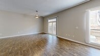 Located at 3400 Stratford Rd NE in Atlanta's Buckhead neighborhood, this single-floor residence offers a thoughtfully designed open-concept layout. Rich hardwood-style flooring flows throughout the space, creating a warm and cohesive aesthetic.

The combined dining and living area is generously proportioned, filled with natural light from large sliding glass doors that open onto a private balcony. A ceiling fan adds comfort, while the open sightlines enhance the sense of space.

The kitchen is a standout feature, showcasing dark espresso cabinetry, white quartz countertops, a subway tile backsplash, a central island with pendant lighting above, and a full suite of stainless steel appliances including a refrigerator, range, microwave, and dishwasher.

The bathroom is well-equipped with a white vanity, framed mirror with lighted fixtures, white cabinetry for storage, and a tiled soaking tub and shower combination. Additional conveniences include a dedicated laundry area, a hallway, and a closet for ample storage.

One accent wall in the living area features a textured stone-like finish, adding a distinctive architectural touch. The neutral color palette throughout creates a clean, modern ambiance suited for a variety of interior styles.