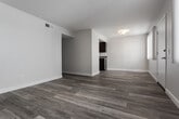 Located at 4620 S Slauson Ave in Los Angeles, this single-story unit offers a clean, modern layout with a cohesive design throughout. Wood-style flooring flows seamlessly across all rooms, lending warmth and continuity to the space. The open living area is bathed in natural light through a large window fitted with vertical blinds, creating a bright and welcoming atmosphere. A hallway connects the main living spaces to the private quarters, providing a well-organized flow through the unit. The kitchen is a functional highlight, featuring rich dark cabinetry, gray stone-look countertops, a stainless steel gas range with overhead microwave, a dishwasher, and ample storage. The bedrooms are generously proportioned, with one offering a sliding mirrored closet door and another benefiting from a window with views of outdoor greenery, filling the room with natural light. The bathroom is neatly appointed with a full tub and shower combination, a dark-cabinet vanity with a white countertop, and brushed nickel fixtures. Throughout the unit, neutral wall tones and clean white trim contribute to a fresh, move-in-ready aesthetic well-suited for comfortable Los Angeles living.