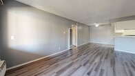 Located at 1901 E Amar Rd in West Covina, CA, this single-floor, one-bedroom, one-bathroom unit offers a practical and comfortable layout. The open living room is finished with contemporary grey-toned vinyl plank flooring and a textured ceiling, creating a clean, modern aesthetic. A wood-burning fireplace anchors one wall of the living area, adding warmth and character to the space. A ceiling fan provides additional comfort, and a built-in wall heater ensures year-round climate control. The galley-style kitchen is well-appointed with white cabinetry, light stone-look countertops, a stainless steel dishwasher, and a gas range. A skylight-style ceiling fixture brightens the kitchen, complementing the light wood-look flooring that runs throughout. The generously sized bedroom features plush carpeting, a window with vertical blinds that invites natural light, and direct access to a closet. The full bathroom is finished with the same light flooring as the kitchen and includes a shower-tub combination and chrome fixtures. Neutral grey walls throughout the unit create a cohesive, move-in-ready environment suitable for a variety of personal styles.