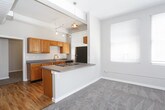 This single-floor unit is thoughtfully laid out, offering a cohesive blend of comfort and practicality across its living spaces. The living area is generously sized, featuring plush neutral carpet, two large windows that invite abundant natural light, and an open connection to the kitchen via a raised countertop bar — ideal for casual dining or entertaining. The kitchen is well-appointed with warm wood cabinetry, gray laminate countertops, a stainless steel sink, and stainless steel appliances including a refrigerator and range, all set over light wood-style flooring.

The bedrooms continue the neutral carpet theme and offer a calm, open feel. One bedroom features notably elevated ceilings with a ceiling fan and a large window, enhancing the sense of spaciousness. Another bedroom includes a sliding-door closet with built-in shelving for organized storage.

Two bathrooms serve the unit. One is a full bath featuring a tub-shower combination, a vanity with warm wood cabinetry, and light wood-style flooring. The second is a three-quarter bath with a pedestal sink, a well-lit mirror, built-in wall shelving, and matching flooring, offering a clean and functional design throughout.