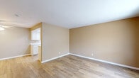 Located in National City, CA, this well-appointed one-bedroom, one-bathroom unit offers efficient single-floor living with a clean, updated aesthetic throughout. Light wood-look flooring runs continuously across all rooms, creating a cohesive and bright atmosphere complemented by warm beige walls and crisp white trim.

The combined kitchen and living area forms the heart of the unit. The kitchen stands out with its distinctive tray ceiling featuring recessed lighting, white shaker-style cabinetry offering generous storage, white countertops, and a full suite of white appliances including a range, microwave, and refrigerator. A double-basin sink and a layout that maximizes counter space make the kitchen both functional and visually clean.

The living area is open and inviting, with vertical blinds covering a large window that allows ample natural light to fill the space. A front entry door opens directly into this area, creating an accessible and welcoming flow.

The bedroom is a comfortable, well-proportioned room with a window dressed in vertical blinds that offer views to the exterior. The room provides a quiet retreat with neutral walls and consistent flooring.

The bathroom is straightforward and functional, featuring a full tub-shower combo with built-in shelving, a toilet, and the same warm neutral palette carried throughout the unit. A dedicated closet completes the layout, providing practical storage within the home.