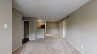 Located at 2500 Lakebrooke Dr in Marietta, Georgia, this single-story unit offers a functional and straightforward layout designed for comfortable everyday living. The open-concept living and dining area is generously proportioned, featuring neutral-toned carpet, gray walls, and a textured ceiling that runs throughout the main living spaces. A pass-through kitchen bar connects the kitchen to the living area, creating an open and accessible flow between the two spaces.

The kitchen is equipped with warm-toned wood cabinetry, dark granite-style countertops, a double stainless steel sink, and stainless steel appliances including an electric range. A dishwasher is also present, adding everyday convenience. Hard surface flooring grounds the kitchen, providing a practical contrast to the carpeted living areas.

The bedrooms are carpeted and well-sized, each featuring windows that admit natural light. One bedroom includes a walk-in closet, providing ample storage. The bathroom features a wide dark wood vanity with a white countertop and undermount sink, accompanied by a large wall mirror with bright overhead lighting. Additional storage closets are accessible throughout the unit. Overall, the space presents a clean, neutral palette suitable for a variety of interior styles.