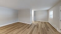 This 450 square foot apartment in Hauppauge, NY, offers a thoughtfully designed living space on a single floor. The open-plan layout maximizes the available area, combining the kitchen and living room for a spacious feel. Large windows flood the space with natural light, while white trim and neutral wall colors create a bright, airy atmosphere. The flooring throughout is a durable, attractive wood-look material that adds warmth to the space.

The kitchen boasts modern amenities, including stainless steel appliances, rich dark wood cabinetry, and granite countertops. A microwave is conveniently mounted above the stove, and ample counter space is available for meal preparation.

The bathroom features clean, white fixtures, including a combination tub and shower with a modern showerhead. A vanity with storage and a large mirror completes the space.

Climate control is provided by baseboard heating and a window air conditioning unit. The entry door includes a window for additional natural light. This efficient apartment is well-suited for individuals or couples seeking a low-maintenance living space in a convenient location.