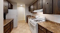 Located at 4980 N Main St in Fall River, Massachusetts, this single-floor unit offers a straightforward and functional layout designed for comfortable everyday living. The open living area is generously proportioned, featuring wall-to-wall carpeting in warm neutral tones, textured ceilings, and baseboard heating throughout. Large windows allow natural light to fill the space while providing views of the surrounding greenery, creating a calm and inviting atmosphere.

The kitchen is well-equipped with dark wood cabinetry offering ample storage, granite-patterned countertops, a gas range, and a full-size refrigerator. Tile flooring and a built-in range hood add to the kitchen's practicality, while a passageway connects it seamlessly to the rest of the unit.

The bedroom is a comfortable, carpeted retreat with a spacious reach-in closet and a window overlooking mature trees, lending the room a serene, private feel. Baseboard heating ensures year-round comfort.

The bathroom features classic yellow tile accents, a combination tub and shower, and tile flooring, delivering a clean and functional design. The overall color palette throughout the unit — soft creams and warm beiges — creates a cohesive and neutral backdrop that is easy to personalize.