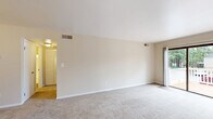 Located at 104 Landmark Ct in Newport News, VA, this single-floor, one-bedroom, one-bathroom home offers a practical and comfortable layout with a neutral, move-in-ready aesthetic throughout. The combined living and dining area is the heart of the home, featuring plush wall-to-wall carpet, warm beige tones, and an abundance of natural light. Large sliding glass doors open directly onto a private deck, offering pleasant outdoor views and seamless indoor-outdoor flow, while an additional window further brightens the space. The galley-style kitchen is efficiently designed with white cabinetry, granite-look countertops, wood-look vinyl flooring, white appliances including a refrigerator and oven, and a window that brings in natural light. The spacious bedroom is carpeted and includes direct access to a hallway leading to the full bathroom, which features a clean white tub-shower combination with chrome fixtures. Three closets provide ample storage throughout the home. A dedicated laundry room and utility room add everyday convenience. Clean white trim and consistent neutral wall tones create a cohesive, bright ambiance throughout this well-organized Newport News home.