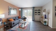 This single-floor residence offers a thoughtfully arranged layout that balances comfort and functionality across its key living spaces. The living room serves as the central gathering area, featuring durable wood-look plank flooring, a warm terracotta accent wall, and a large sliding glass door that fills the room with natural light and provides access to an outdoor area. The open sightlines connect seamlessly to the dining space, creating an inviting flow throughout.

The galley-style kitchen is efficiently designed, featuring white cabinetry with contemporary hardware, dark granite-style countertops, stainless steel appliances including a refrigerator and electric range, and wood-look flooring that continues the cohesive aesthetic.

Both bedrooms are carpeted for comfort, with neutral grey walls and ample room for full furniture arrangements. One bedroom benefits from a window that brings in natural light, while both rooms offer access to closet storage, including a walk-in closet area.

The two bathrooms are finished with wood-look flooring and dark countertops. One features a single vanity with a large mirror and modern fixtures, while the other includes a full bathtub and shower combination with brushed nickel hardware, offering practical everyday functionality throughout the residence.