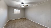 Located at 1839 S Glenbrook Dr in Garland, TX, this single-story, 2-bedroom, 1-bathroom home offers a practical and comfortable layout designed for efficient everyday living. The combined living, dining, and kitchen area forms the heart of the home, featuring light wood-look flooring that extends throughout the main space. The kitchen is equipped with white shaker-style cabinetry, granite countertops, a stainless steel double sink, and black appliances, alongside a dedicated pantry for additional storage. A hallway connects the main living area to the private sleeping quarters. The spacious primary bedroom features plush carpeting, a ceiling fan with light fixture, a window for natural light, and multiple closets offering generous storage. The second bedroom also features carpet flooring, a ceiling fan, and a window, with one wall showcasing an exposed brick-style painted surface that adds a distinctive character to the room. The full bathroom is cleanly appointed with a white tile tub-and-shower surround, a white vanity with granite countertops, modern black light fixtures, and wood-look flooring. Textured ceilings are consistent throughout the home, and neutral wall tones create a cohesive, move-in-ready aesthetic across all rooms.