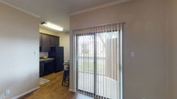This well-appointed 1-bedroom, 1-bathroom unit is thoughtfully designed to maximize functionality across its single-floor layout. The living area greets you with warm hardwood-style flooring, crown molding, and a ceiling fan, creating a clean and inviting atmosphere. A sliding glass door fitted with vertical blinds opens to a private balcony, allowing natural light to pour in while offering pleasant views of the surrounding greenery.

Adjacent to the living space, the kitchen is efficiently laid out with rich dark-stained cabinetry, granite-look countertops, a stainless steel sink, and black appliances including an electric range with overhead ventilation. A breakfast bar provides a casual dining option, adding to the kitchen's practicality.

The bedroom offers a comfortable retreat with plush carpeting, a ceiling fan, and a window that brings in soft natural light. Crown molding adds a refined touch to the space. The bathroom features a dark-wood vanity with a granite-look countertop, an inset sink, and a well-placed mirror, complemented by textured walls that give the room character.

Throughout the unit, neutral tones and consistent finishes create a cohesive, easy-to-personalize aesthetic, making this a practical and comfortable living space.