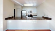 Located at 109 Church St in the heart of New Haven, CT, this two-floor space offers a thoughtfully designed layout with a range of quality finishes throughout. Rich hardwood flooring runs across the living areas, catching natural light that streams in through large windows fitted with blinds, creating a bright and welcoming atmosphere.

The kitchen is a functional centerpiece, featuring crisp white cabinetry, dark granite countertops, and a full suite of stainless steel appliances including a refrigerator, range with microwave above, and a double-basin sink. A generous counter overhang provides a natural breakfast bar or prep area, while a louvered closet door offers additional storage nearby.

The living spaces are open and airy, with clean white walls, warm wood flooring, and windows that invite abundant natural light. The staircase, visible in the model overview, connects the two floors and showcases the same warm wood tones found throughout.

The bathroom is well-appointed with light tile flooring, white cabinetry topped with dark granite countertops, a recessed toilet paper holder, and a full soaking tub with an overhead shower and tiled surround. The overall design of the space balances practical functionality with clean, modern aesthetics, making it a comfortable and versatile environment.