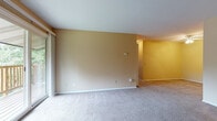 Located at 201 Swanton Rd in Madison, Wisconsin, this single-floor unit offers a practical and comfortable layout throughout. The generously sized living area features soft carpeting, warm neutral-toned walls, and a sliding glass door that opens to an outdoor balcony with a railing, allowing natural light to fill the space. A wall-mounted air conditioning unit and baseboard heating are present for year-round comfort. A ceiling fan adds additional airflow to the adjoining dining or flex area.

The galley-style kitchen is well-appointed with warm oak cabinetry, dark laminate countertops, a double-basin sink, and white appliances including a refrigerator, electric range, and dishwasher. Tile flooring runs through the kitchen, providing easy maintenance.

Two carpeted bedrooms offer quiet retreats, each with natural light from windows overlooking greenery. One bedroom features a spacious walk-in closet with built-in shelving, while the other includes a standard closet. Both rooms are served by baseboard heating.

The full bathroom is finished with tile flooring, a wide oak vanity with ample cabinet storage, a large mirror, and a tub-shower combination. Clean white walls and fixtures complete the functional design of this well-laid-out Madison residence.