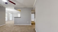 Located in Cypress, TX, this single-story, 2-bedroom, 1-bathroom home offers a functional and comfortable layout designed for easy everyday living. The interior is finished with neutral gray walls and plush carpeting throughout the living and bedroom areas, creating a cohesive and inviting atmosphere.

The open living area features crown molding, a ceiling fan with light fixture, and multiple windows fitted with blinds that allow ample natural light to fill the space. A pass-through counter connects to the kitchen area, enhancing the open feel of the main living zone.

The primary bedroom is generously sized, boasting vaulted ceilings, a ceiling fan, and a sliding glass door with vertical blinds that opens to an outdoor view, bringing in abundant natural light. The second bedroom also features carpeted floors, a ceiling fan, and a built-in closet with bifold doors for convenient storage.

The bathroom is clean and well-equipped, featuring a combined shower and soaking tub with tiled surround, wood-look flooring, and modern brushed nickel fixtures. A hallway connects the rooms efficiently, and a dedicated closet provides additional storage throughout the home. Ceiling fans are present in multiple rooms, ensuring year-round comfort throughout this practical and neatly maintained home.