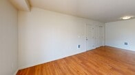 Located in Airway Heights, WA, this 3-bedroom, 2-bathroom single-floor unit offers a practical and well-organized layout across a comfortable footprint. The open-concept living area combines the kitchen, dining, and living spaces into one cohesive zone, anchored by warm hardwood-style flooring throughout. The kitchen features a peninsula with a double-basin sink, ample cabinetry with warm wood-tone finishes, and black appliances including a refrigerator, electric range, microwave, and dishwasher. The living room receives generous natural light through a large window and sliding glass door that opens to a private patio with outdoor views. Both bathrooms are finished with wood-tone vanity cabinetry, countertop sinks, large mirrors, and hardwood-style flooring. One bathroom includes a full shower-tub combo. The three bedrooms are carpeted and bright, each featuring closets — including sliding door closets — for ample storage. The primary bedroom offers a comfortable, well-proportioned space. Additional features include in-unit laundry and multiple closets throughout. The unit's neutral color palette and clean finishes create a move-in-ready environment suited for a variety of living arrangements.