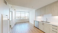 Located in the heart of San Diego, CA, this modern one-bedroom, one-bathroom residence offers a thoughtfully designed open-concept layout filled with natural light. Light oak hardwood flooring flows throughout, complementing the clean, contemporary aesthetic.

The combined living, dining, and kitchen area serves as the centerpiece of the home. The kitchen features floor-to-ceiling light wood cabinetry, a white subway tile backsplash, stainless steel appliances including a refrigerator with ice maker, range, microwave, and dishwasher, along with light countertops and a single-basin sink. Large floor-to-ceiling windows provide sweeping city views and flood the living and dining area with abundant natural light.

The bedroom is a bright, serene retreat with generous corner windows framing urban views, creating an airy atmosphere. A dedicated closet provides convenient storage.

The bathroom is finished with elegant marble-look tile on both the floors and shower surround. It includes a soaking tub, toilet, and a wood-toned vanity with a mirrored medicine cabinet. A private balcony extends the living space outdoors, ideal for enjoying San Diego's pleasant climate. Recessed lighting throughout ties the entire residence together with a polished, modern feel.