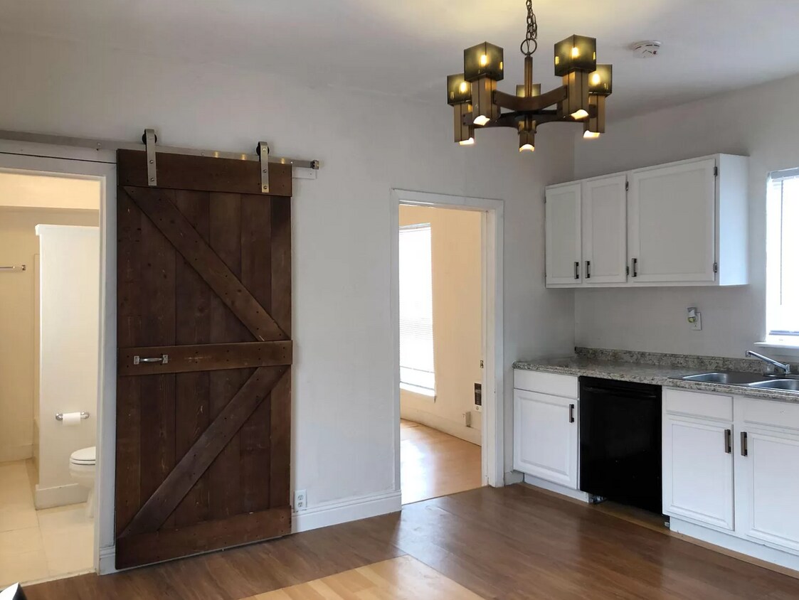 Kitchen. Barn door leads to bathroom. - 4926 Reiger Ave