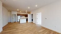 Located at 2665 Kingsgate Way in Richland, Washington, this single-floor unit offers a clean, modern design with a thoughtfully planned open-concept layout. Light-toned luxury vinyl plank flooring flows throughout the main living areas, creating a bright and cohesive aesthetic. The open living and dining area is generously proportioned, providing flexible space for a variety of furniture arrangements, and is illuminated by recessed ceiling lights.

The kitchen is a standout feature, equipped with rich dark-stained cabinetry that extends to the ceiling for ample storage, light quartz countertops, a stainless steel double-basin sink with a professional-style faucet, a stainless steel range, and a stainless steel refrigerator. A kitchen island with additional counter space adds functionality, while stylish black pendant lights overhead enhance the contemporary feel. An in-unit washer is tucked conveniently into a dedicated closet adjacent to the main living area.

The bedrooms are finished with neutral carpet and crisp white walls, offering quiet, comfortable retreats. The bathrooms feature dark wood vanities with light quartz countertops, large mirrors, and tile flooring. Five-panel interior doors with matte black hardware are consistent throughout, contributing to the unit's modern, cohesive design. A hallway connects the private areas of the unit with ease and efficiency.