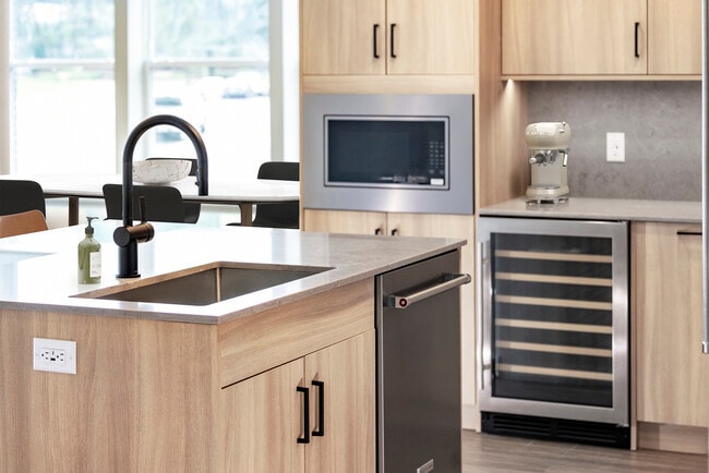 Signature Collection kitchen with stainless steel appliances (wine fridge included), quartz countertops, quartz tile backsplash, oak cabinetry, and hard-surface flooring - Avalon Parsippany