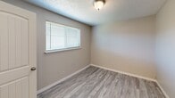 Located at 13621 Pacific Ave S in Tacoma, WA, this one-bedroom, one-bathroom unit offers a functional and well-maintained living space spread across a single floor. The interior is finished with light gray wood-look vinyl plank flooring throughout, complemented by neutral warm-toned walls and textured ceilings that create a clean, cohesive aesthetic.

The galley-style kitchen is a standout feature, outfitted with white shaker cabinetry, light quartz-style countertops, a double-basin sink with a modern faucet, a white electric coil-top range, and a full-size refrigerator. Natural light filters in through a window, brightening the space. Flush-mount light fixtures provide additional illumination.

The bedroom is a comfortably sized private retreat featuring a window with blinds that allows for natural light, textured ceiling, and the same consistent flooring found throughout the unit. A dedicated closet offers practical storage, and a hallway connects the living areas efficiently.

The bathroom includes a full-size soaking tub and shower combo with a white surround, a window for ventilation and natural light, and gold-toned fixtures including a grab bar and towel bar. The overall layout is straightforward and practical, making efficient use of the available space while maintaining a tidy, move-in-ready appearance.