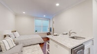Located at 70 Polifly Rd in Hackensack, NJ, this thoughtfully designed studio makes efficient use of its single-floor layout. The open-concept main area seamlessly integrates the living, sleeping, and dining functions, finished with warm hardwood flooring and crown molding that lend a polished, cohesive aesthetic. Recessed lighting brightens the space throughout, while a large window fitted with blinds allows natural light to fill the room.

The kitchen is a standout feature, boasting sleek white cabinetry, granite countertops, and a breakfast bar with seating for two. Stainless steel appliances — including a refrigerator, dishwasher, and range — complement the clean, contemporary design. A stacked washer and dryer unit is conveniently integrated into the kitchen area, offering in-unit laundry without sacrificing style.

The bathroom is clean and modern, featuring a full soaking tub with shower, a wall-mounted vanity with brushed nickel fixtures, and a mirrored medicine cabinet. White tile walls and light flooring create a bright, spa-like atmosphere.

Throughout the space, neutral tones, crisp white walls, and carefully chosen finishes contribute to an inviting and functional environment — ideal for those seeking a well-appointed, move-in-ready residence in Hackensack.
