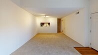 Located at 2093 E 83rd Ct in Tulsa, Oklahoma, this one-bedroom, two-bathroom residence offers a well-organized single-floor layout designed for comfortable everyday living. The living room is a welcoming focal point, featuring vaulted ceilings that lend an open, airy feel, soft carpeting underfoot, and a corner fireplace that adds warmth and character. A sliding glass door floods the space with natural light and provides access to the outdoors. The kitchen is efficiently designed in a U-shaped galley configuration, showcasing rich dark wood cabinetry, light marble-style countertops, stainless steel appliances including a refrigerator, range, and built-in microwave, and durable hardwood-style flooring. A pass-through window connects the kitchen to the living area, enhancing the open feel. The generously sized primary bedroom features plush carpeting, neutral walls, and a large window that invites natural light and outdoor views. The two bathrooms include hardwood-style flooring, white tile shower surrounds with tub combinations, and marble-style countertops. A hallway with hardwood-style flooring connects the rooms, completing this thoughtfully laid-out Tulsa residence.