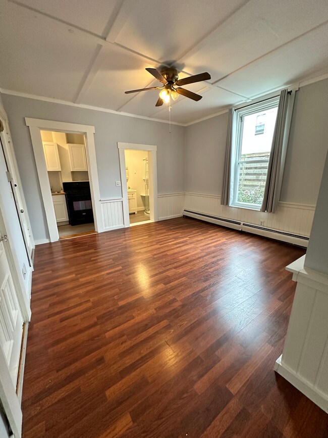 Large living room with natural light and access centrally located to kitchen, bathroom, and bedroom. - 7 Maple Ave