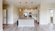 Located at Liberty Enclave Drive in Huntersville, NC, this well-appointed two-bedroom, two-bathroom residence offers a thoughtfully designed single-floor layout filled with modern finishes throughout. The open-concept kitchen serves as the centerpiece of the home, showcasing granite countertops, white shaker cabinetry, a classic subway tile backsplash, and a full suite of stainless steel GE appliances — including a French door refrigerator, range, and microwave. A large kitchen island with an integrated sink and elegant pendant lighting makes the space ideal for both cooking and entertaining. Light wood-look flooring flows throughout the main living areas, lending a clean, contemporary feel. The bedrooms are carpeted for comfort and feature neutral tones, generous windows with blinds that invite natural light and outdoor views, and dedicated closets with wire shelving. The primary bathroom impresses with a dual-sink vanity topped with granite, white cabinetry, and a large mirror. The secondary bathroom offers a full tub-shower combo with brushed nickel fixtures. A dedicated laundry room houses a full-size washer and dryer with overhead shelving for added storage. Two closets and a pantry area provide ample storage throughout this comfortable and functional home.