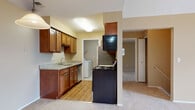 This single-floor residence offers a practical and comfortable layout designed for everyday living. The kitchen is a standout feature, appointed with warm medium-toned wood cabinetry, granite countertops, a stainless steel sink, and hardwood-style flooring. Appliances include a range, dishwasher, refrigerator, and over-the-range microwave, providing a fully equipped cooking space. A dedicated in-unit laundry area is conveniently accessible directly from the kitchen and houses a full-size GE washer and dryer with additional shelving for storage.

The bedrooms are finished with plush wall-to-wall carpeting and neutral warm-toned walls, creating a comfortable and restful atmosphere. Each bedroom benefits from generous closet space with built-in shelving. Natural light filters into the bedrooms through windows fitted with vertical blinds.

The bathrooms are finished with tile flooring, granite-topped vanities with undermount sinks and wood cabinetry, and a tub-and-shower combination enclosed by sliding glass doors. The entryway features tile flooring and a glass-panel front door that allows natural light into the space, offering a welcoming transition from the outdoors. Overall, the residence combines functional design with quality finishes throughout.