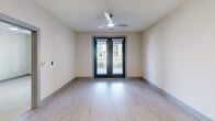 Located at 4285 Julep Way SW in Aiken, South Carolina, this single-floor, one-bedroom, one-bathroom residence offers a thoughtfully designed layout with modern finishes throughout. The open-concept living and kitchen area features light wood-tone flooring, recessed lighting, and a clean, contemporary aesthetic. The kitchen is a standout space, equipped with rich dark-brown shaker cabinetry, a marble-style tile backsplash, white quartz countertops, a central island, and a full suite of stainless steel appliances including a refrigerator, range, microwave, and dishwasher. A second kitchen area, as noted in the floor plan, provides additional utility and storage. The living area opens via French doors to an outdoor view, enhanced by a ceiling fan and abundant natural light. The bedroom is a comfortable retreat featuring plush carpet flooring, a ceiling fan, and a window with outdoor views. The walk-in closet offers generous wire shelving for organized storage. The bathroom presents a sleek double-vanity with dark cabinetry and white countertops, a large mirror, and light wood-tone flooring. The overall ambiance of the residence is clean, bright, and modern, making it a well-rounded living space in Aiken, SC.