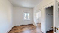 Located at 180 S Cannon St in Spokane, Washington, this one-bedroom, one-bathroom unit offers a thoughtfully organized layout across a single floor. Classic architectural details are present throughout, including crown molding, clean white walls, and warm hardwood-style flooring that runs consistently through each room, lending a cohesive and inviting character to the space.

The bedroom is generously proportioned for the overall footprint, featuring framed windows that invite natural light and offer views of the surrounding neighborhood. A dedicated closet provides practical storage, while the white paneled doors with brass hardware add a refined, traditional touch visible from the connecting hallway.

The kitchen is functional and compact, equipped with white cabinetry, a turquoise countertop with an integrated sink, and a full-size refrigerator. A large window overlooks lush tree canopy, filling the space with greenery and daylight.

The bathroom stands out with its charming clawfoot bathtub fitted with a shower attachment—an elegant nod to classic design. A wood-vanity with a vessel-style sink, a window admitting natural light, and wood-look flooring complete the room's vintage-inspired aesthetic.

A hallway connects the rooms efficiently, contributing to the smooth flow of the layout. This unit combines historic character with practical functionality in a central Spokane location.