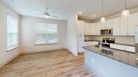 Located at 40 Pallet Rd in Candler, NC, this well-appointed single-story home offers three bedrooms and three full bathrooms within a thoughtfully designed floor plan. Light-toned hardwood flooring flows throughout the main living areas, complemented by crisp white walls and ceiling fans in every room, creating a clean, airy aesthetic throughout.

The open-concept kitchen, dining, and living area serves as the heart of the home. The kitchen features white shaker-style cabinetry, dark granite countertops, a tile backsplash, stainless steel appliances, a peninsula island with pendant lighting, and recessed ceiling lights. A large window fills the adjoining dining area with natural light.

Each of the three bedrooms is carpeted and equipped with a ceiling fan. The primary bedroom includes a walk-in closet and direct access to its own bathroom. Additional bedrooms feature windows overlooking greenery, providing a tranquil atmosphere. The living room offers hardwood flooring, multiple windows, and direct access to the patio.

All three bathrooms are finished with white cabinetry, dark granite countertops, large mirrors, brushed nickel fixtures, and tub-shower combinations with tiled surrounds. The primary bath includes a double-sink vanity. Four closets provide ample storage throughout the home, and a patio extends the living space outdoors.