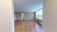 Located at 1501 Maple Ave in Evanston, IL, this single-floor residence offers a thoughtfully laid-out living space with a variety of functional rooms. The spacious living area is highlighted by warm hardwood flooring, neutral gray walls, and a textured ceiling. Large windows fitted with blinds allow generous natural light to fill the room while offering views of the surrounding Evanston neighborhood. A baseboard heating system and wall-mounted air conditioning unit ensure year-round comfort.

The kitchen is well-appointed with warm wood cabinetry, dark laminate countertops, white tile flooring, and a full suite of appliances including a range, microwave, dishwasher, and refrigerator. A window above the counter brings in additional natural light, and an open passageway connects the kitchen seamlessly to the main living area.

The bedroom features plush wall-to-wall carpeting, large windows with outdoor views, and generous closet space with built-in shelving — ideal for organized storage. A second carpeted room provides similar comfort and versatility.

The bathrooms are clean and functional, each featuring tile flooring, a tub-shower combination, a single-basin vanity with under-sink storage, and a mirrored medicine cabinet with bright vanity lighting above. The overall ambiance of the unit is bright, practical, and move-in ready.
