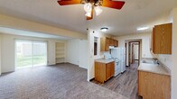 Located at 1845 Winding Hill Rd in Davenport, Iowa, this single-floor, 2-bedroom, 3-bathroom unit offers a functional and comfortable layout. The open-concept kitchen and living area forms the heart of the home, where warm oak cabinetry, ample counter space, and white appliances — including an electric range, refrigerator, and dishwasher — make for a well-equipped kitchen. Wood-look flooring runs through the kitchen and hallways, while plush carpet adds comfort to the living and bedroom areas. The living room is bright and inviting, featuring a ceiling fan with light fixture, a sliding glass patio door that fills the space with natural light and provides views of the surrounding greenery, and a built-in shelving unit ideal for display or storage. Two hallways connect the rooms efficiently throughout the unit. The primary bedroom is generously sized, offering a double sliding-door closet and neutral tones throughout. The second bedroom also features carpeted flooring and a window with natural light. Three bathrooms serve the unit, each with oak vanity cabinetry, mirrored medicine cabinets, and clean white fixtures. One bathroom includes a full tub/shower surround. Textured ceilings are present throughout, adding a classic touch to the overall aesthetic.