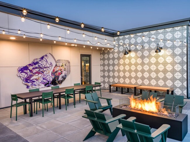 Unwind under the stars at Modera Woodstock's outdoor terrace, featuring a warm and inviting firetable. - Modera Woodstock