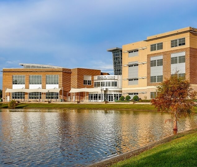 A lake in front of the Wayne M. Densch Partnership Center