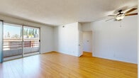 Located at 10933 Huston St in North Hollywood, this 2-bedroom, 2-bathroom unit offers a well-organized single-level layout. The bright and open living room is finished with warm hardwood-style flooring and features a textured ceiling and sliding glass door that opens to a private balcony with open neighborhood views, filling the space with natural light. The kitchen is thoughtfully equipped with stainless steel appliances including a gas range, built-in microwave, and dishwasher, complemented by white cabinetry with wood trim accents, light countertops, and tile flooring. A window above the sink brings in additional natural light. Both bedrooms are carpeted and generously windowed, offering pleasant outdoor views of palm trees and surrounding greenery. The primary bedroom provides a comfortable retreat with ample wall space. The second bedroom also features hardwood-style flooring, offering flexibility in use. The two bathrooms are finished with tile flooring; one includes a skylight above the shower/tub combo, a vanity with mirrored cabinet, and clean white fixtures. A hallway connects the rooms efficiently, completing this functional and comfortable layout in a convenient Los Angeles neighborhood.