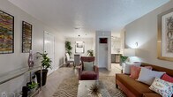 This thoughtfully designed 2-bedroom, 2-bathroom single-floor residence offers a functional and stylish layout with quality finishes throughout. The open-concept living and dining area forms the heart of the home, featuring a distinctive herringbone-patterned luxury vinyl floor, a textured ceiling, and warm, neutral-toned walls. The living area provides ample space for relaxing, while the adjacent dining nook is highlighted by a modern circular pendant light and a glass-top dining table. The kitchen is outfitted with stainless steel appliances, two-tone cabinetry in white and gray, light quartz countertops, and matching herringbone flooring — a clean and contemporary cooking space. A central hallway connects the bedrooms and bathrooms, maintaining a clear and organized flow. Both bedrooms are carpeted for comfort, feature ceiling fans with lighting, and receive natural light through windows with outdoor views. The primary bedroom offers a generous footprint with room for a full furniture suite. Each bathroom is finished with gray vanity cabinetry, quartz countertops, and one includes a full tub-shower combination with white tile surround. The entryway makes a welcoming first impression with herringbone floors continuing from the main living space.