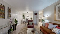This thoughtfully designed 2-bedroom, 2-bathroom single-floor residence offers a functional and stylish layout with quality finishes throughout. The open-concept living and dining area forms the heart of the home, featuring a distinctive herringbone-patterned luxury vinyl floor, a textured ceiling, and warm, neutral-toned walls. The living area provides ample space for relaxing, while the adjacent dining nook is highlighted by a modern circular pendant light and a glass-top dining table. The kitchen is outfitted with stainless steel appliances, two-tone cabinetry in white and gray, light quartz countertops, and matching herringbone flooring — a clean and contemporary cooking space. A central hallway connects the bedrooms and bathrooms, maintaining a clear and organized flow. Both bedrooms are carpeted for comfort, feature ceiling fans with lighting, and receive natural light through windows with outdoor views. The primary bedroom offers a generous footprint with room for a full furniture suite. Each bathroom is finished with gray vanity cabinetry, quartz countertops, and one includes a full tub-shower combination with white tile surround. The entryway makes a welcoming first impression with herringbone floors continuing from the main living space.