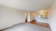 Located at 212 E Wedgewood Ave in Spokane, WA, this single-floor unit offers a practical and well-organized layout designed for comfortable everyday living. The open-concept living area combines plush carpeting with wood-look flooring, creating a clear visual distinction between relaxation and transition spaces. A sliding glass door leads to a private balcony, bringing in natural light and outdoor views. Baseboard heating runs throughout the unit, ensuring consistent warmth during Spokane's cooler months. The textured ceilings add a classic residential character to the space.

The kitchen is efficiently laid out with a coil-burner electric range, full-size refrigerator, over-the-range microwave, and ample cabinetry. A peninsula counter separates the kitchen from the living area, providing additional workspace and a casual dining option. Wood-look flooring continues through the kitchen for easy maintenance.

Two bedrooms offer carpeted floors and closet storage, with one bedroom featuring a window that allows natural light to filter in. The in-unit water heater is conveniently housed within a closet in one of the bedrooms. The full bathroom is clean and functional, featuring a tiled tub-shower combination, a vanity with storage, and wood-look flooring that ties the space together cohesively.