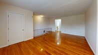 This 1-bedroom, 1-bathroom residence at 1424 Nottingham Way in Trenton, NJ offers a clean, functional layout across a single floor. Rich, polished hardwood floors flow throughout the living room, bedroom, and hallway, lending warmth and continuity to the space. The living room is generously proportioned, bathed in natural light from large windows fitted with blinds, and equipped with a wall-mounted air conditioning unit and baseboard heating for year-round comfort. The spacious bedroom continues the hardwood flooring and features multiple windows offering outdoor views, a closet, and the same baseboard heating system. The kitchen is well-equipped with warm wood cabinetry, dark granite-style countertops, a double sink, a gas range, and a full-size refrigerator, all set atop easy-care tile flooring. The bathroom is neatly appointed with a wood-vanity cabinet, white countertop, a combined tub and shower with white tile surround, a safety grab bar, and a window that allows natural light. A connecting hallway ties the rooms together efficiently. Neutral wall tones throughout create a bright, welcoming ambiance suitable for a variety of décor styles.