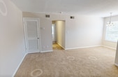 Located on the third floor at 6123 Edward St in Norfolk, VA, this 2-bedroom, 2-bathroom apartment spans 680 square feet of well-organized living space across a single floor. The unit features a pass-through kitchen equipped with warm wood cabinetry, white appliances including a refrigerator and electric range, a built-in range hood, and a countertop sink — all visible from the adjacent carpeted living area. Both bedrooms are carpeted and feature textured ceilings, neutral beige walls, and windows with blinds that bring in natural light and outdoor views of surrounding greenery. The primary bedroom measures 200 square feet and includes access to a dedicated closet. The second bedroom also features a walk-in closet. Each bathroom is appointed with wood-toned vanity cabinetry, white countertops, and vanity lighting with a large mirror. One bathroom includes a shower-tub combination with hard surface flooring, while the other features a similar clean, functional design. Two closets throughout the unit provide ample storage. The floor plan offers a straightforward and efficient layout well-suited for everyday living.