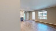 Located at North Grove in Riverside, CA 92501, this 1-bedroom, 1-bathroom apartment offers 600 square feet of thoughtfully designed living space across two floors. The modern exterior features a contemporary stucco facade with large windows, set within a well-maintained multi-story residential community. Inside, the open living area is finished with light-toned hardwood-style flooring and neutral-toned walls, creating a bright and airy ambiance. The kitchen is a standout feature, boasting shaker-style cabinetry in a soft gray-white finish, stainless steel appliances including a refrigerator, range, microwave, and dishwasher, complemented by a classic white subway tile backsplash and recessed lighting. The primary bedroom spans 120 square feet and is carpeted for comfort, featuring multiple windows that invite abundant natural light and views of the surrounding palm tree-lined neighborhood. The bathroom is clean and functional, offering a single-vanity with blue shaker cabinetry, a large mirror, and a shower-tub combination with hardwood-style flooring. A dedicated closet and hallway complete the layout. A balcony provides outdoor views of the community and surrounding area, adding to the appeal of this well-appointed urban residence.