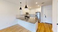 This thoughtfully designed one-bedroom, one-bathroom residence in Titusville, NJ offers a bright and modern living experience across a single, well-organized floor. The open-concept layout seamlessly connects the living room, dining area, and kitchen, all finished with light hardwood flooring that enhances the airy feel of the space. Large windows flood the living area with natural light and frame views of the surrounding community, while a private balcony extends the living space outdoors.

The contemporary kitchen is a standout feature, equipped with white shaker cabinetry, a herringbone tile backsplash, granite countertops, stainless steel appliances — including a gas range, microwave, dishwasher, and French door refrigerator — and a peninsula with pendant lighting above, ideal for casual dining or entertaining.

The bedroom is carpeted for comfort, features a ceiling fan, and offers a generous window with outdoor views. Two closets provide ample storage throughout the unit. The bathroom is finished with classic black-and-white hexagonal tile flooring, a warm wood vanity with dark countertop, and matte black fixtures. Additional conveniences include an in-unit laundry area, completing this well-appointed modern residence.