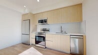 This 360 square foot apartment in Los Angeles offers a well-designed living space that makes the most of its compact footprint. The unit features an open-concept layout with a single bedroom and bathroom. The kitchen area is equipped with modern stainless steel appliances, including a full-sized refrigerator, oven with cooktop, and over-the-range microwave. Light wood cabinetry and white countertops create a bright, contemporary aesthetic.

The bathroom showcases a clean design with a combined tub and shower enclosed by a glass door, enhancing the sense of space. A large mirror and good lighting contribute to the bathroom's functional and inviting atmosphere.

The bedroom, measuring 100 square feet, includes a sliding door closet for efficient storage. Throughout the apartment, light-colored walls and wood-look flooring create a sense of continuity and openness. Natural light filters through windows, including a balcony door in the kitchen area, brightening the space and offering a connection to the outdoors.

Despite its modest size, the apartment's thoughtful design and modern finishes provide a comfortable and stylish urban living environment. The location in the heart of Los Angeles at 7050 Hawthorn Ave adds to its appeal for those seeking a centrally located, low-maintenance home.