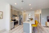 Located at 650 N Sgt Ed Holcomb Blvd in Conroe, TX, this single-floor, 2-bedroom, 2-bathroom residence offers a thoughtfully designed layout with modern finishes throughout. The open-concept living, dining, and kitchen area serves as the heart of the home, bathed in natural light from large windows framed by elegant drapes. The living room features light-toned flooring, a ceiling fan, and a bright, airy ambiance. The kitchen is outfitted with gray shaker-style cabinetry, subway tile backsplash, stainless steel appliances, and a marble-topped island with bar seating — ideal for casual dining and entertaining. Light wood-look flooring flows throughout the main living areas. The primary bedroom offers plush carpeting, a clean white palette, and access to a walk-in closet with multi-tier shelving. The bathrooms are finished with marble-style countertops, gray cabinetry, and tiled shower-tub combinations. A dedicated in-unit laundry room houses a full-size washer and dryer. With three closets total, a hallway, and well-defined room separations, this residence balances comfort and practicality in a polished, contemporary setting.
