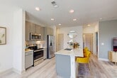 Located at 650 N Sgt Ed Holcomb Blvd in Conroe, TX, this single-floor, 2-bedroom, 2-bathroom residence offers a thoughtfully designed layout with modern finishes throughout. The open-concept living, dining, and kitchen area serves as the heart of the home, bathed in natural light from large windows framed by elegant drapes. The living room features light-toned flooring, a ceiling fan, and a bright, airy ambiance. The kitchen is outfitted with gray shaker-style cabinetry, subway tile backsplash, stainless steel appliances, and a marble-topped island with bar seating — ideal for casual dining and entertaining. Light wood-look flooring flows throughout the main living areas. The primary bedroom offers plush carpeting, a clean white palette, and access to a walk-in closet with multi-tier shelving. The bathrooms are finished with marble-style countertops, gray cabinetry, and tiled shower-tub combinations. A dedicated in-unit laundry room houses a full-size washer and dryer. With three closets total, a hallway, and well-defined room separations, this residence balances comfort and practicality in a polished, contemporary setting.